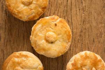 Stuffed chicken pie known as Empada in Portugal and Brazil. Group of snacks on rustic wood, flat lay design.