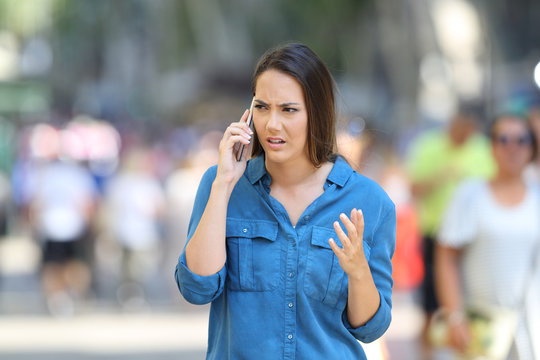 Angry woman claiming on phone on the street