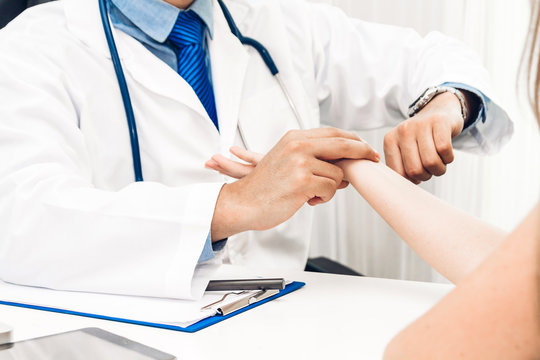 Doctor checking female patient's pulse in hospital.healthcare and medicine