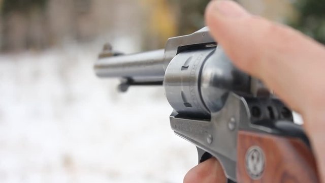Revolver pistol being shoot outdoors. 