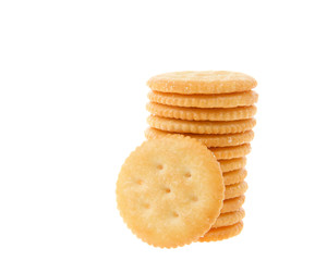 Round salted crackers stacked with one cracker in front isolated on white