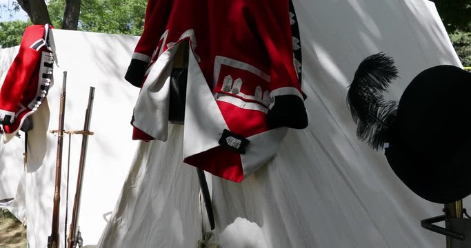 Revolutionary War British Uniforms Tent And Rifle. Modern Day Re Enactment At City Park Celebration. Red Coat, White Tents, Feather Hat And Musket Rifle Weapons. British Or English.