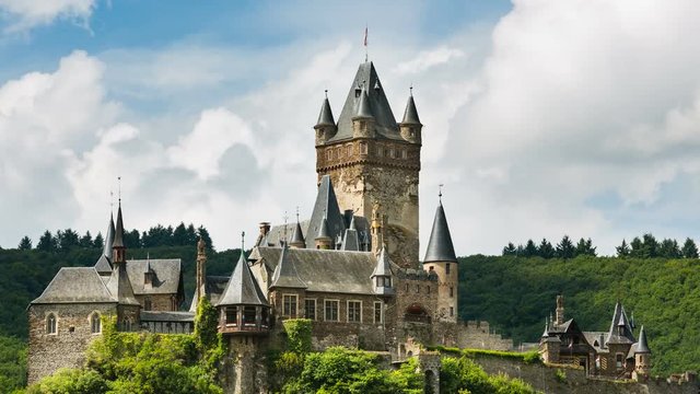 Zooming summer timelapse sequence of the Reichsburg Cochem in the Moselle Valley in Germany with fast moving clouds in the background in 4K resolution.
