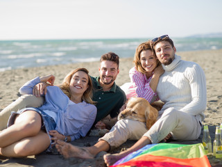 Obraz premium Group of friends having fun on beach during autumn day