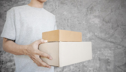 a man holding parcel boxes package, on concrete texture backgrounds