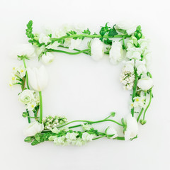 Naklejka premium Floral frame composition of white ranunculus, snapdragon and tulip flowers on white background. Flat lay, top view.