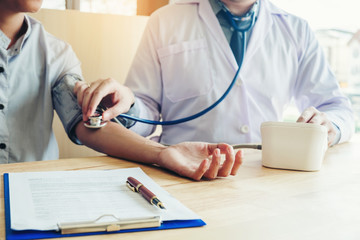 Doctor Measuring arterial blood pressure woman patient on right arm Health care in hospital