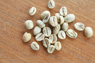 Raw coffee beans on wooden background top view