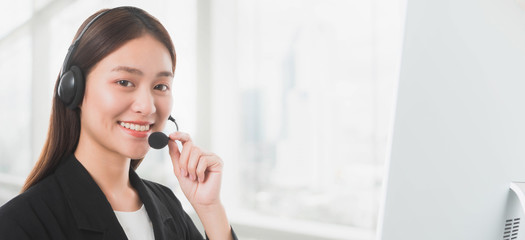 Portrait of Asian beautiful smiling woman customer support phone operator in office space background and copy space.Concept call center job service.