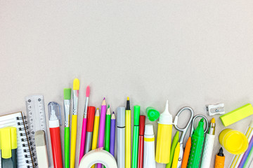 variety of school supplies on grey table background. back to school concept