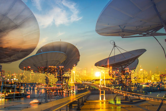 Double Exposure Of Satellite Dish With City In The Night