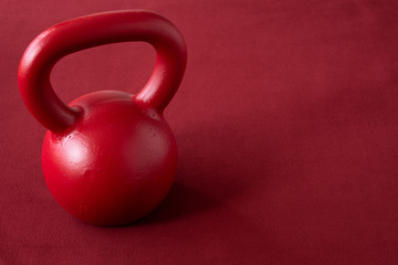 Naklejka na ściany i meble Red kettle bell on a red background 