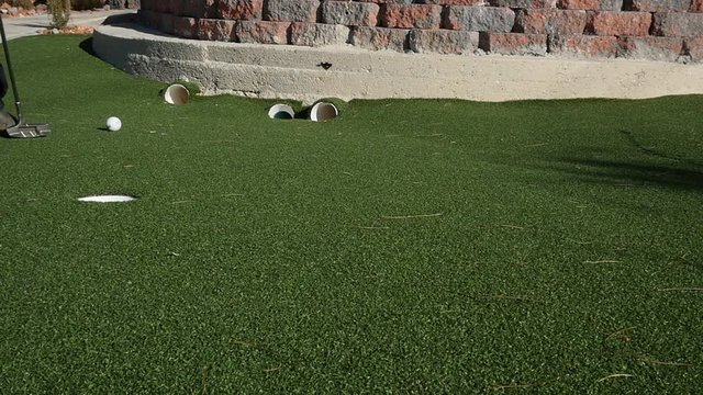 Little boy mini golfing cheat.