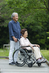 車いすで散歩する老夫婦