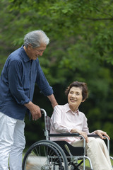 車いすで散歩する老夫婦
