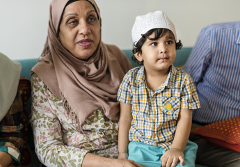 Muslim boy sitting with his grandmother