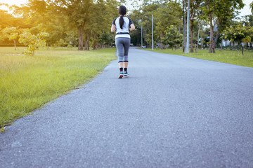 Fototapeta premium Woman runner running on road at plubic park jogging in sunrise light