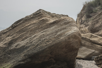 large sea boulders lie on the beach