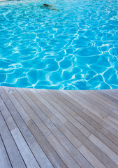 Fototapeta na wymiar piscine bleue avec terrasse en bois 
