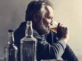 Elderly man sitting drinking whiskey alcoholic addiction bad habit