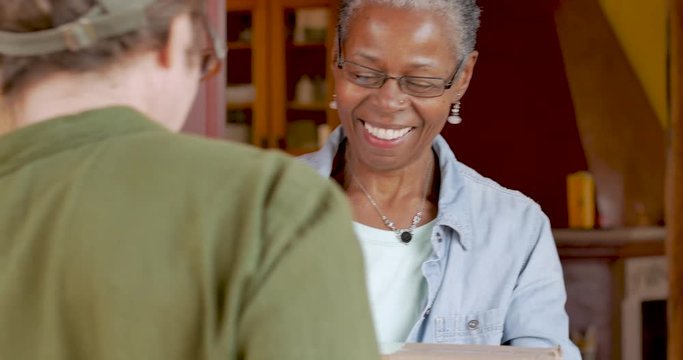 Happy elderly black woman receiving home delivery package delivery