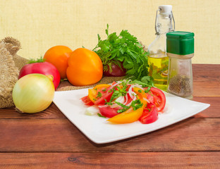Salad of red and yellow tomatoes and ingredients for preparation