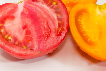 Halves of yellow and red tomatoes at selective focus