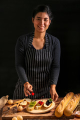 Chef was preparing the french baguette for starter food, decorated with various fruits, kiwi, cherries and blueberries.