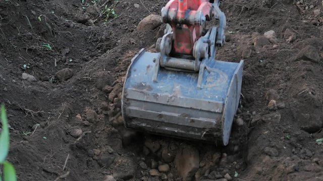 Low pov excavting dirt with back hoe