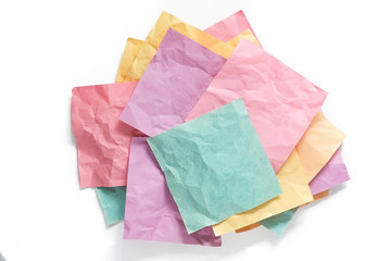 Stack of crumpled sticky reminder notes with shadows