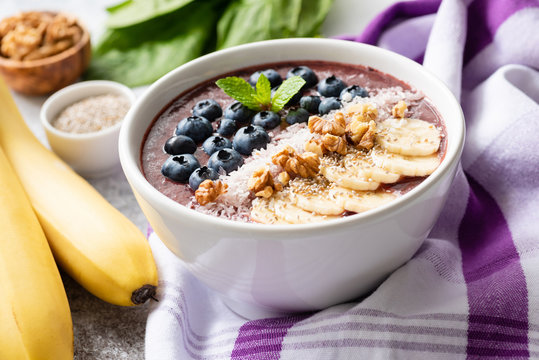 Acai smoothie bowl with superfood toppings - chia seeds, walnut, coconut, blueberries and sliced banana. Detox vegan diet, healthy lifestyle and healthy eating concept