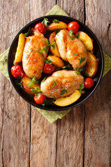 Sour sweet chicken breast baked with peaches, tomatoes, onion, parsley and honey garlic sauce close-up. Vertical top view
