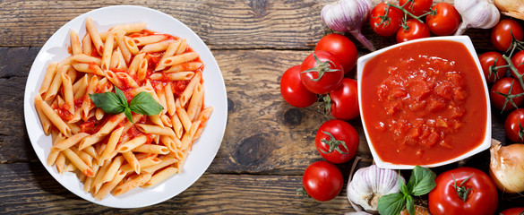 plate of pasta with tomato sauce on wooden table