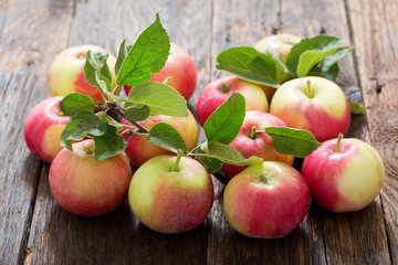 fresh apples with leaves on a table
