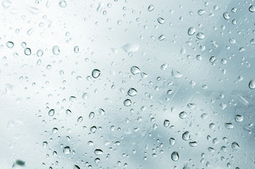 Textured background of window panes with a cloudy background. Natural pattern from a drop of rain on a cloudy background.