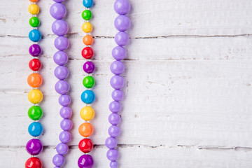 Colorful beautiful bright beads necklace on a wooden background by summer