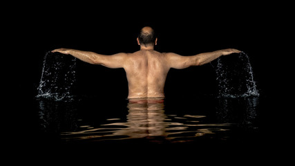 Fototapeta na wymiar A man standing inside the water and spreads his arms