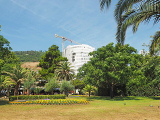 Hotel building under construction. Development of resort territory. Crane upon tropical background.