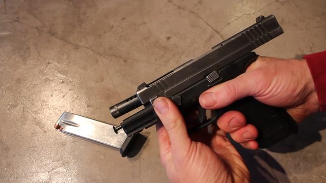 Man Disassembles a handgun