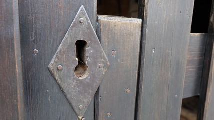 Old heavy wooden gate witha large metal key hole