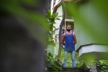 Young man with black hair and beard in the Park in a summer evening