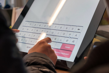 Tourist hand touching display at self-service transfer machine. buying airplane or train tickets at...
