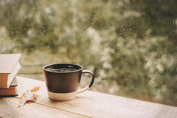 Cup of tea at a rainy window autumn mood day leaf