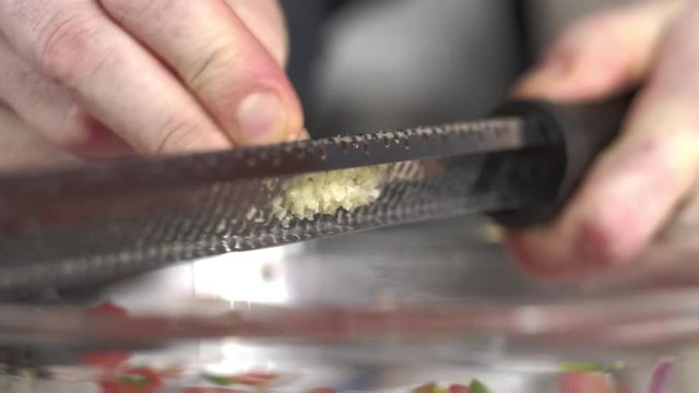 Close-up shot of chef grating fresh garlic clove