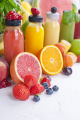 Many different fruits and berries and juices in plastic bottles. Watermelon, banana, applesin, blueberries, strawberries, basil. Vitamin and healthy food. Copy space.