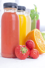 Many different fruits and berries and juices in plastic bottles. Watermelon, banana, applcsin, blueberries, strawberries, basil on a white background. Vitamin and healthy food. Detox. Copy space.