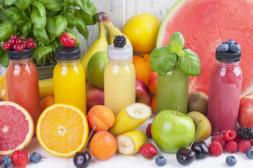 Many different fruits and berries and juices in plastic bottles. Watermelon, banana, applesin, blueberries, strawberries, basil. Vitamin and healthy food. Copy space.