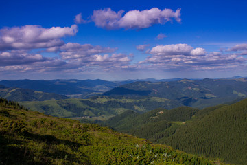 Obraz premium Zdjęcie górskiego krajobrazu latem pod pięknym pochmurnym niebem. Ukraina, Karpaty, wieś Dzembronia.