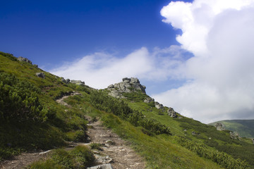 Fototapeta premium Photo of mountain landscape in the summer under beautiful cloudy sky. Ukraine, Carpathians, Dzembronia village.