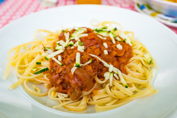 Italian linguine with vegan bolognese sauce based on soy beans and vegetables served on a white plate